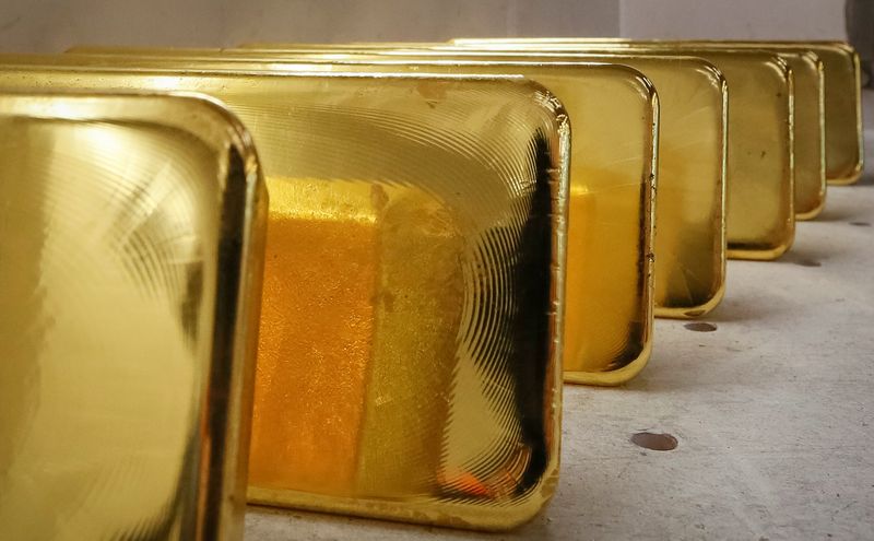 Barras de ouro alinhadas em perspetiva com reflexos dourados