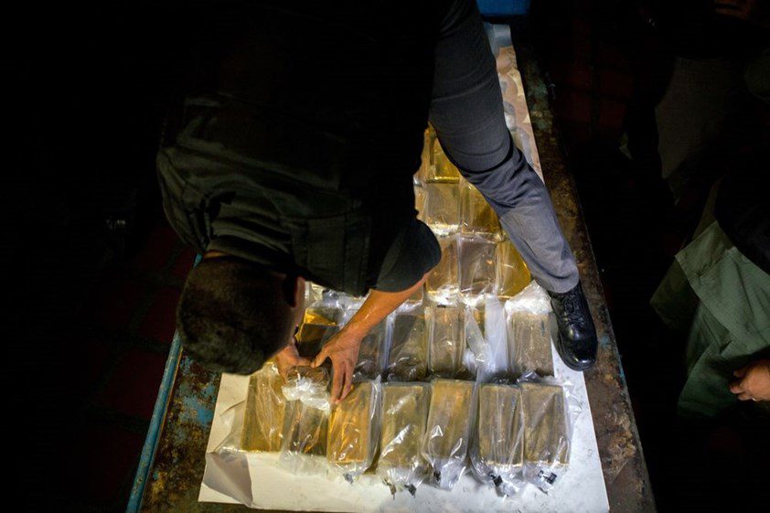 Barras de ouro embaladas em sacos plásticos sobre uma mesa
